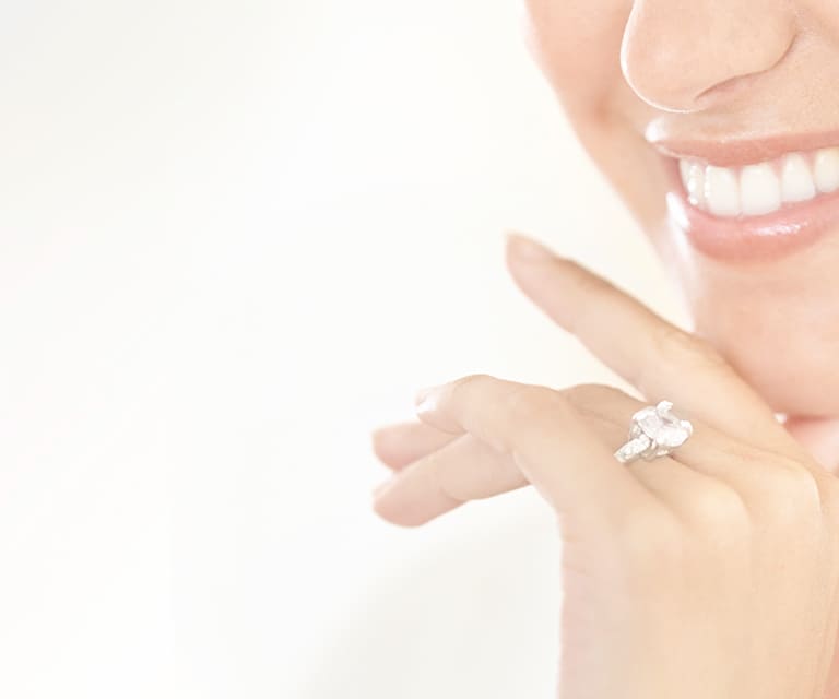 Lady smiling wearing a diamond ring